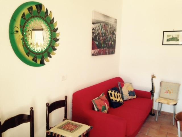 トッレ・ラピッロにあるCasa Vacanze Torre Lapilloのリビングルーム(赤いソファ、鏡付)