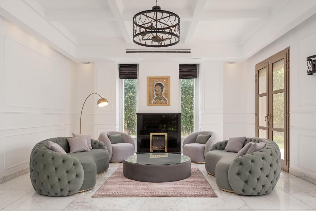 uma sala de estar com dois sofás e uma lareira em Luxury Allegria Golf Villa with pool em Sheikh Zayed