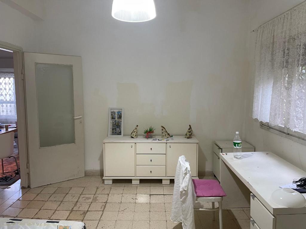 a bathroom with a sink and a vanity with a pink stool at Asaf place in Haifa