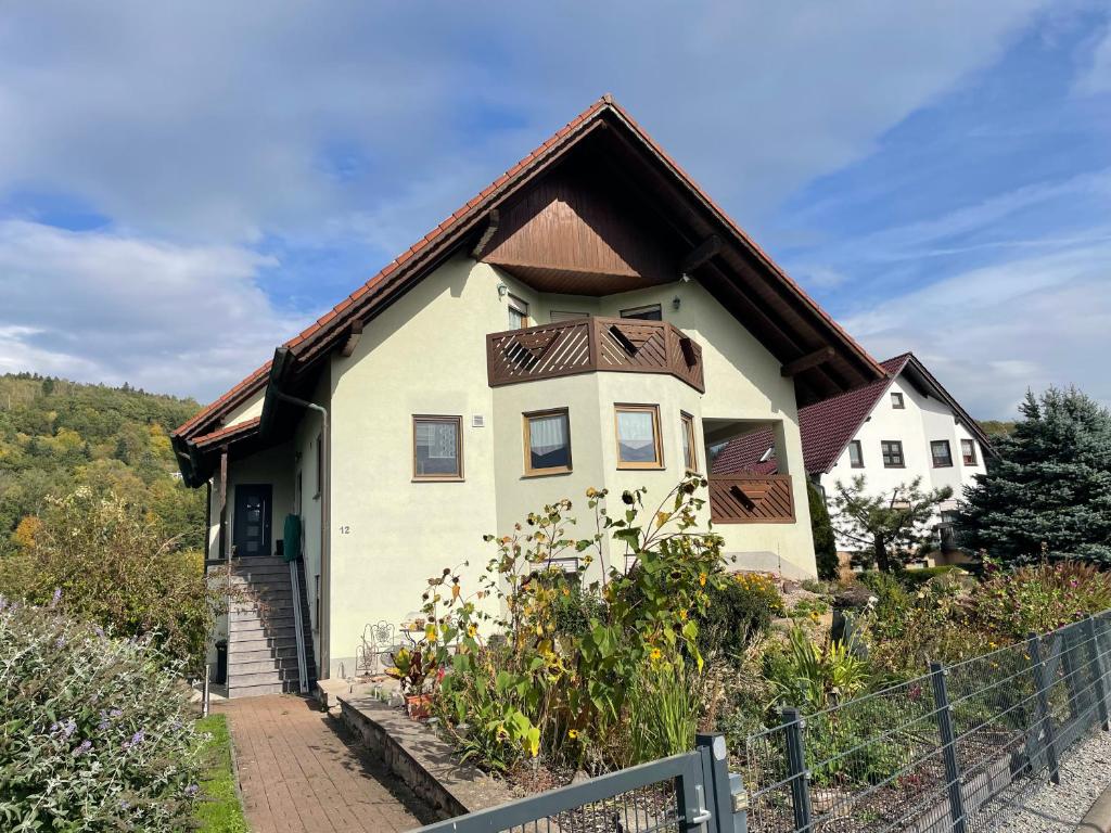 una casa blanca con techo marrón en Ferienwohnung Fam.Werner, en Wasungen