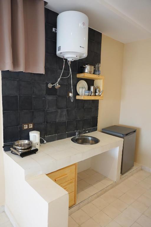 a kitchen counter with a sink in a room at SurfAppart Morocco in Tamraght Ouzdar