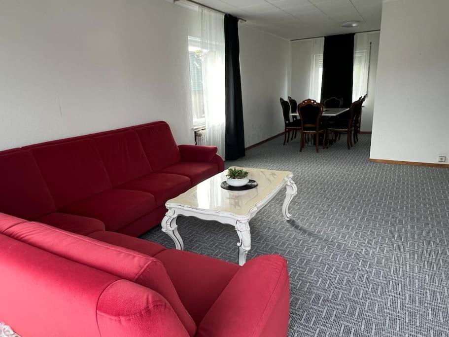 Sala de estar con sofá rojo y mesa de centro en Wohnung in Herford, en Herford