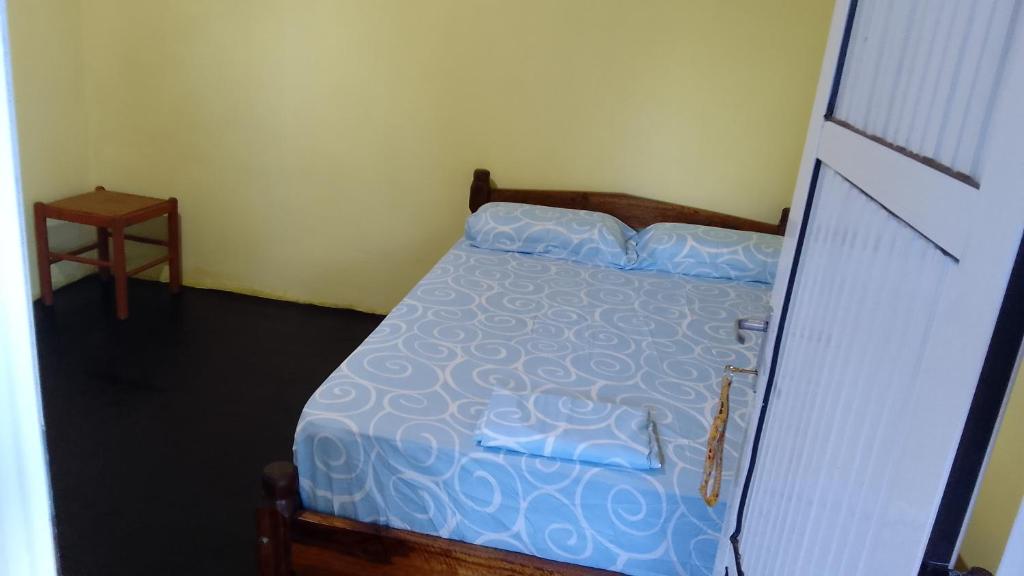 a bedroom with a bed with a blue comforter at Hospedaje jabuticaba in El Soberbio
