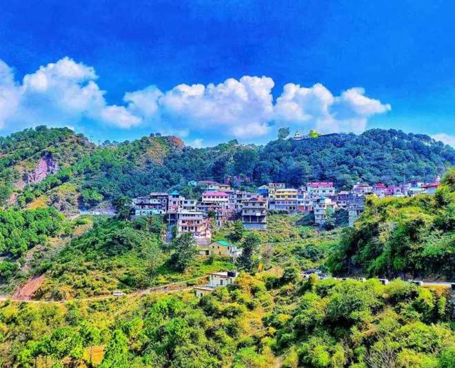 a village on a hill with houses on it at Hotel Pleasing Pines in Dagshai