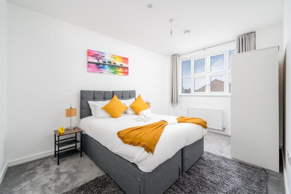 a bedroom with a large bed with yellow pillows at Luxury 2 Bedroom Apartment Free Parking, Netflix, Sleeps 6 in Watford
