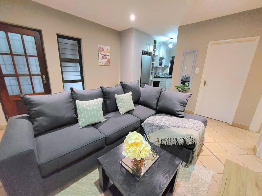 uma sala de estar com um sofá e uma mesa em Pamuzinda Airbnb at Urban Cove em Nelspruit