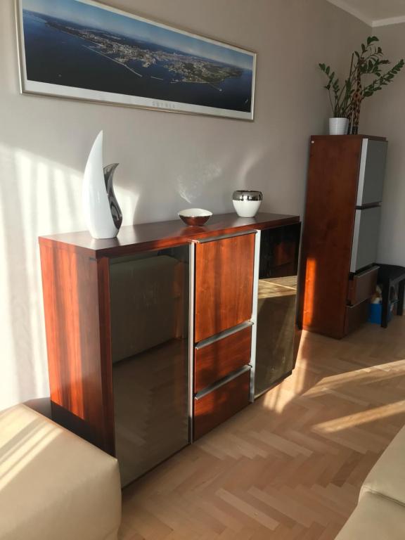 a wooden entertainment center in a living room at Apartament Jantarowa in Gdynia