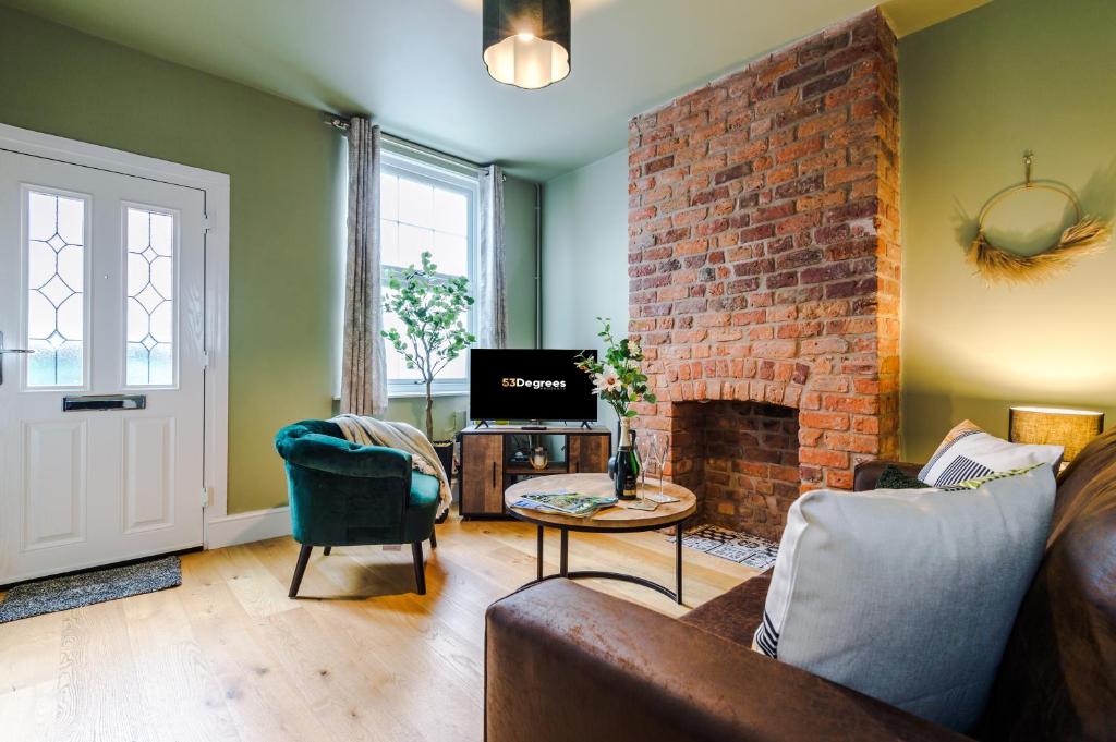 a living room with a couch and a brick fireplace at NEW! Gorgeous 2-bed home in Chester City Centre by 53 Degrees Property - Incredible location, Ideal for Small Groups - Sleeps 6! in Chester