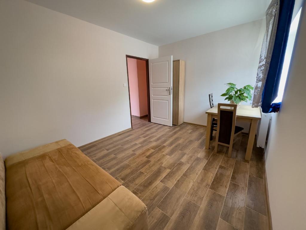 sala de estar con mesa, sofá y escritorio en Apartament 4 osobowy obok Szpitala Brzeziny 2 pokoje Prywatna łazienka i kuchnia 32m2, en Brzeziny
