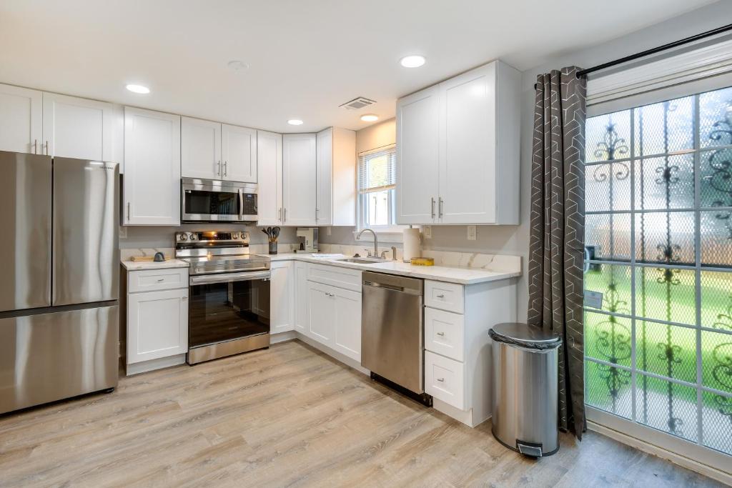 una cucina con armadietti bianchi ed elettrodomestici in acciaio inossidabile di 3 Mi to Six Flags America Upper Marlboro Retreat! a Largo