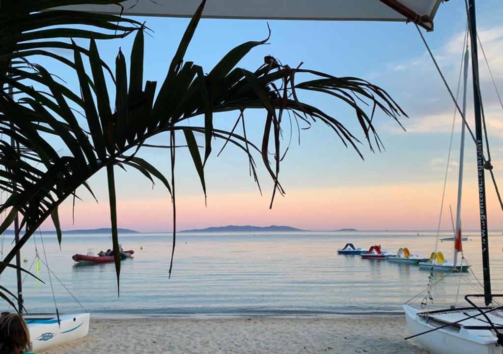 - une vue sur une plage avec des bateaux dans l'eau dans l'établissement Duplex face mer . Cavalière le Lavandou 3 chambres, au Lavandou