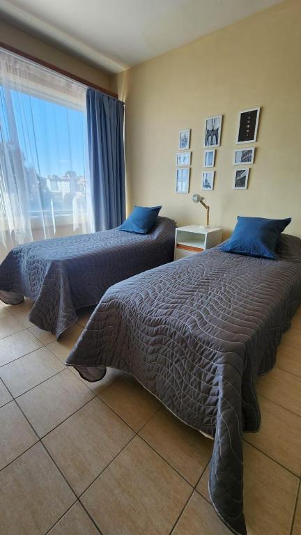 Dos camas sentadas en una habitación con ventana. en Estudio Brendel a metros del Centro Cívico, en San Carlos de Bariloche