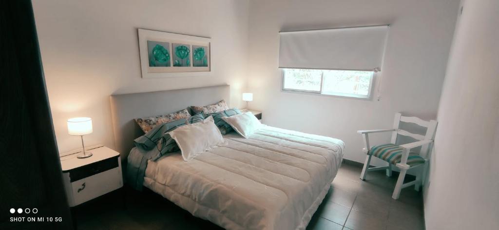 ein Schlafzimmer mit einem Bett und einem Stuhl und einem Fenster in der Unterkunft Casa de Montaña María Tequila in Villa Giardino