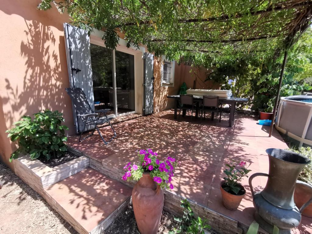 une terrasse avec une table et des fleurs. dans l'établissement T2 indépendant terrasse et piscine au calme Var sud de la France, à Flassans-sur-Issole