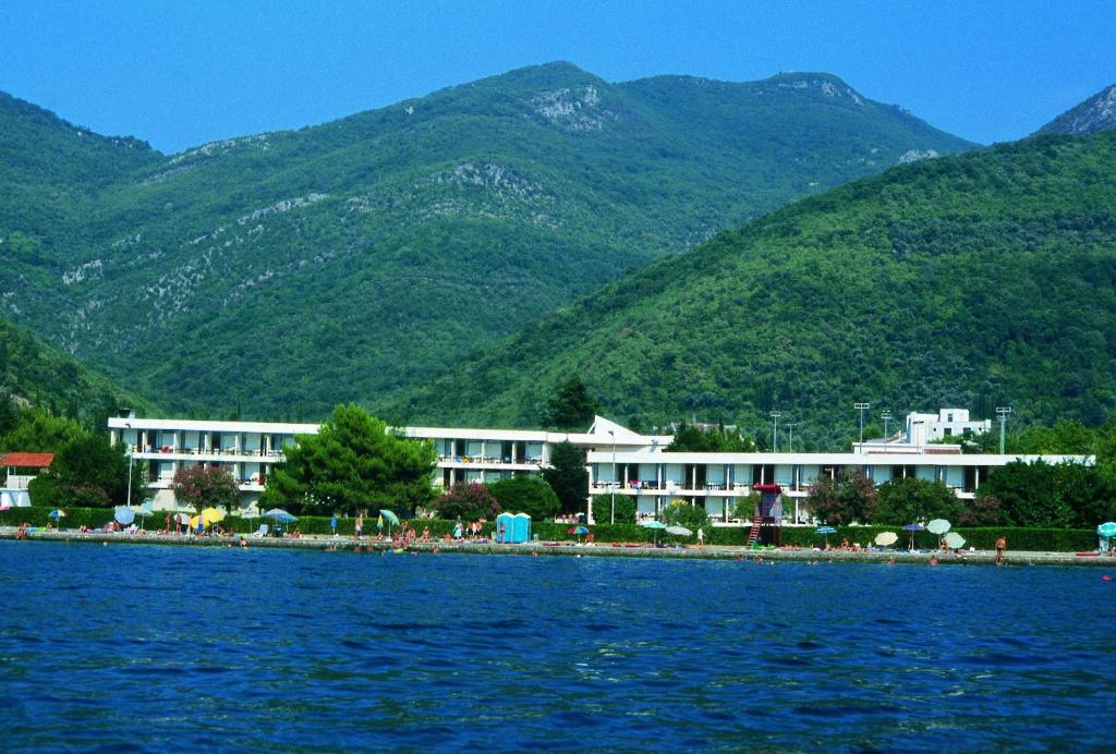 eine Gruppe von Gebäuden am Ufer eines Wasserkörpers in der Unterkunft Hotel Kamelija in Tivat
