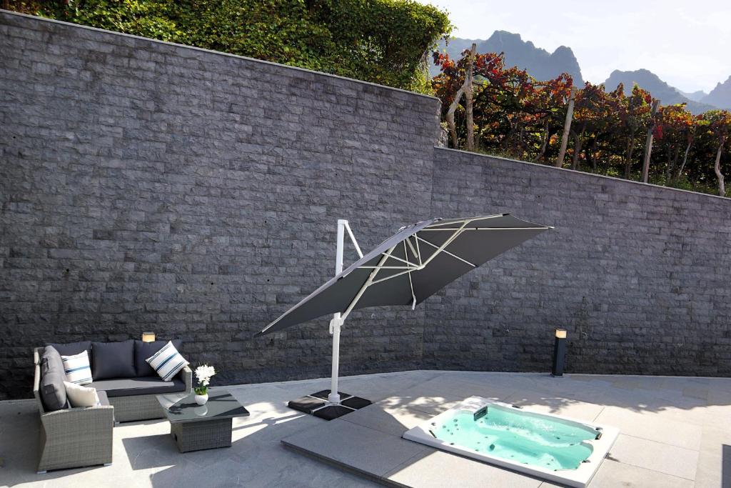 a patio with an umbrella and a pool at Casa Da Achada, By OP in São Vicente