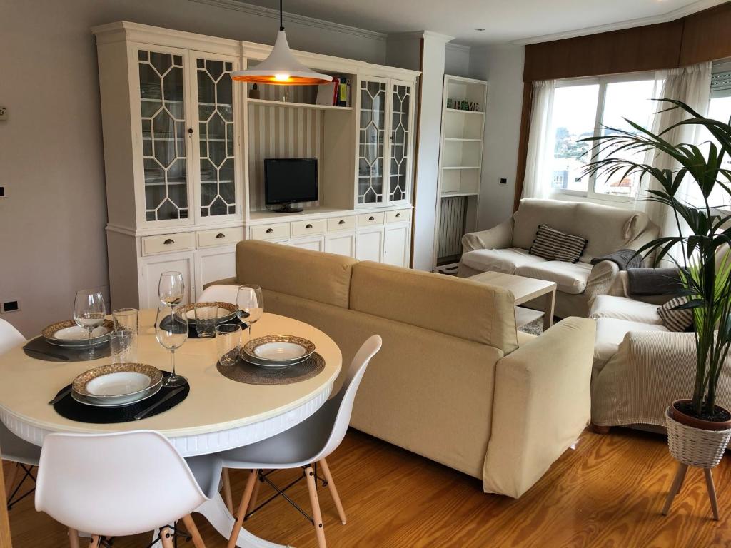 a living room with a couch and a table and chairs at Increíbles vistas *CENTRO* in Pontevedra