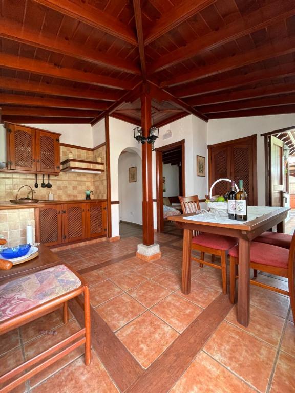 a kitchen with wooden ceilings and a table and chairs at Casa de colon in Los Silos