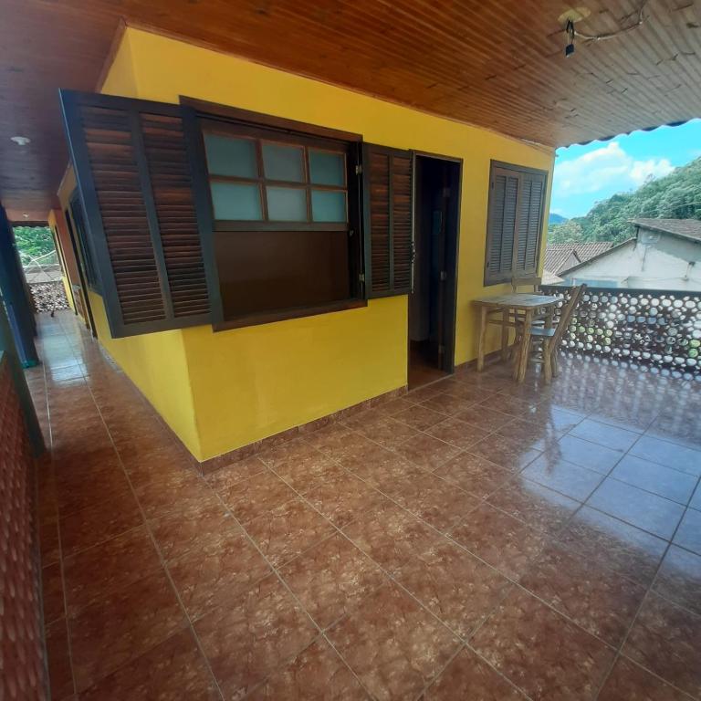 a yellow house with a table and chairs at Suite Maromba in Núcleo Mauá