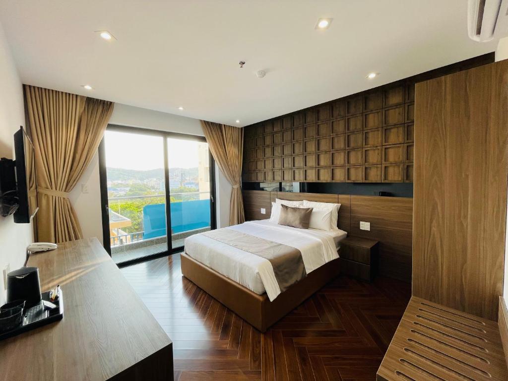 sypialnia z łóżkiem i dużym oknem w obiekcie Hải Long Hotel 2 w mieście Vung Tau