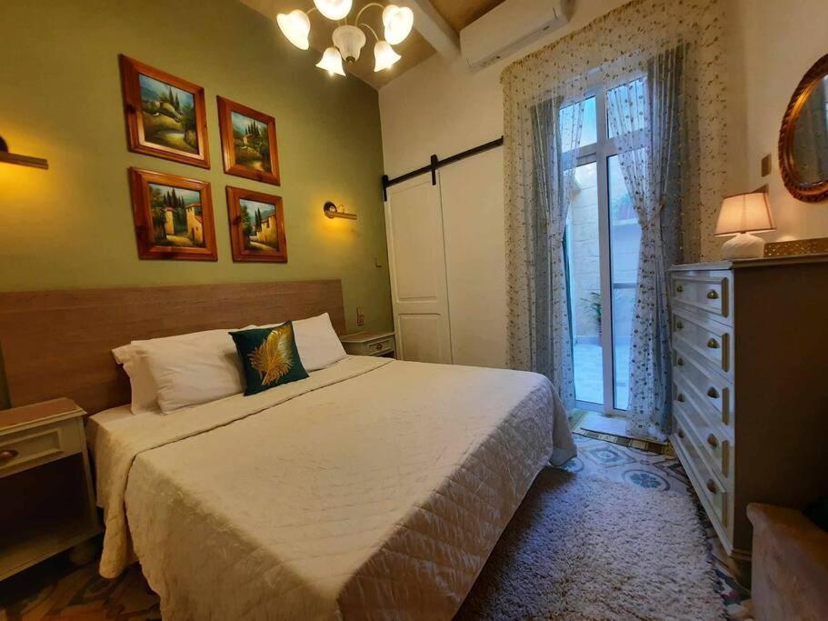 a bedroom with a bed and a dresser and a window at Bizzilla Lodging Suite in Mqabba