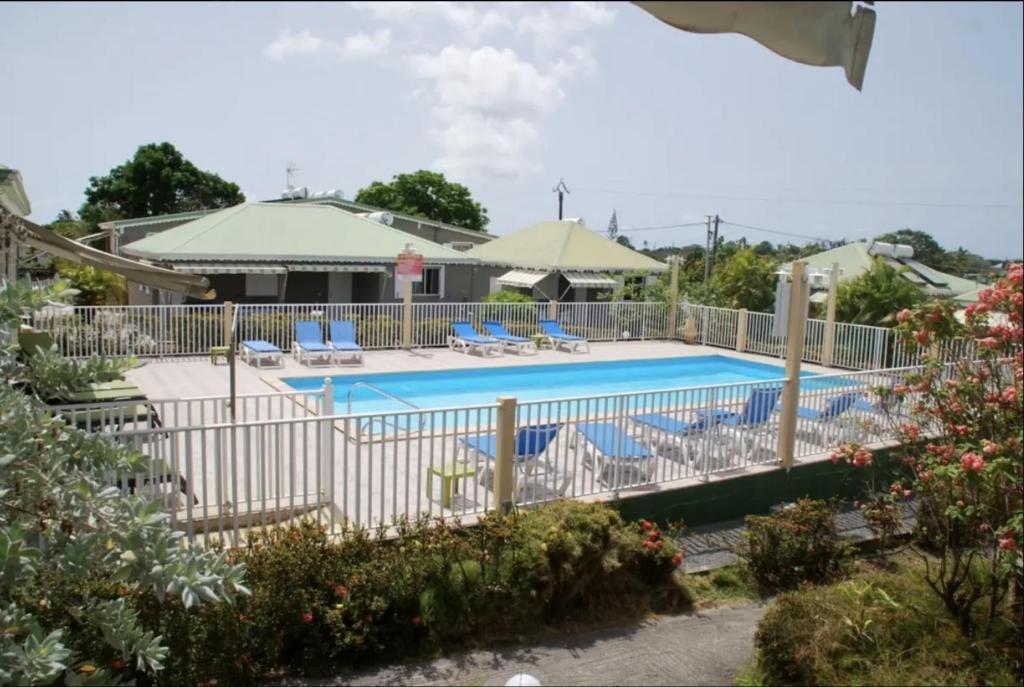 a swimming pool with chairs and a fence at Village de Bragelogne in Saint-François