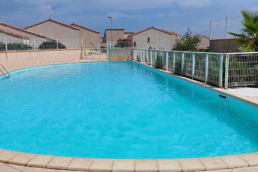 une grande piscine avec de l'eau bleue dans l'établissement Nice house with pool - near the beach, à Saint Pierre La Mer