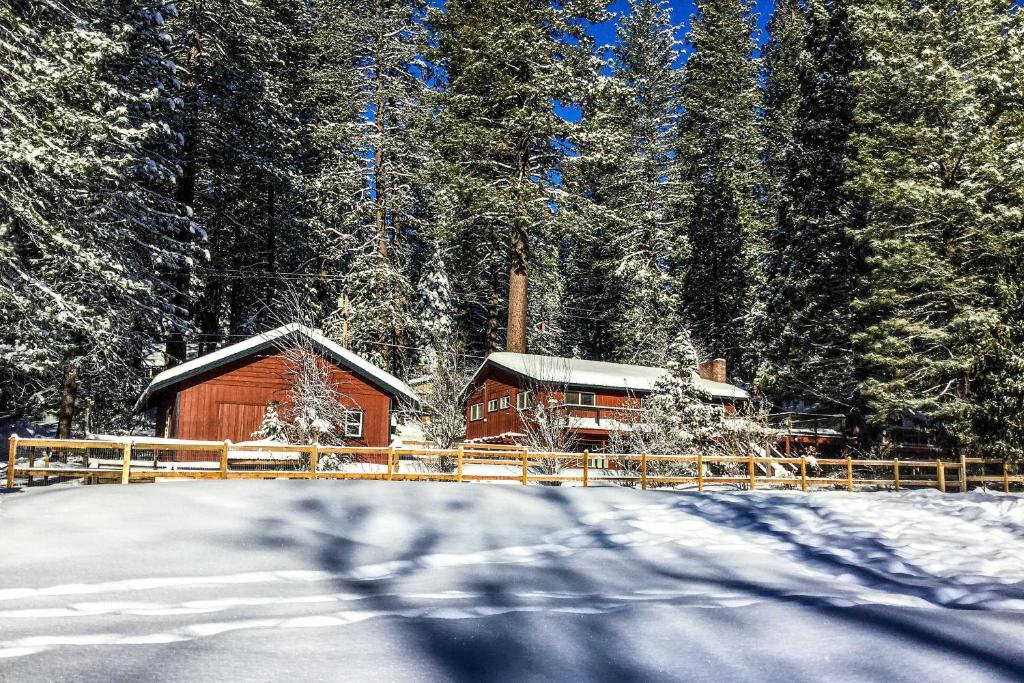 una cabaña de madera en la nieve con árboles en Enchanting Cabin with Deck and Natl Forest Views, en Arnold