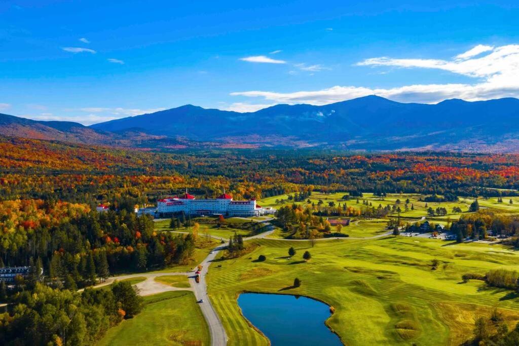 an aerial view of a golf course with a lake and mountains at Large 5 bedroom Bretton Woods Townhome 1 gig WiFi in Bretton Woods