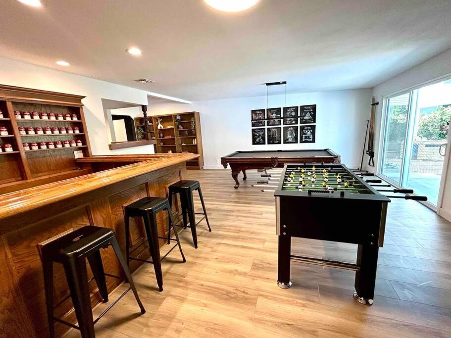 a room with a pool table and a bar with stools at Spacious 4BR in Los Angeles in Los Angeles