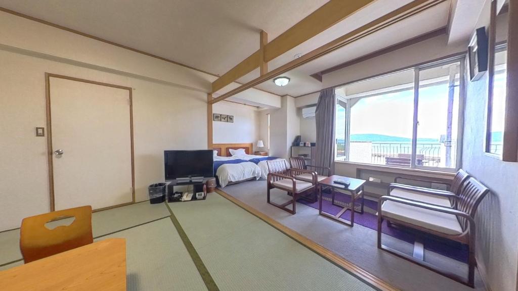 Una sala de estar con una cama y un televisor. en HOTEL GREEN PLAZA SHODOSHIMA - Vacation STAY 71488v, en Ikisue