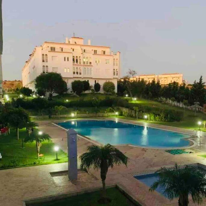 a large swimming pool in front of a large building at appartement de vacances achakar avec plage&piscine in Tangier