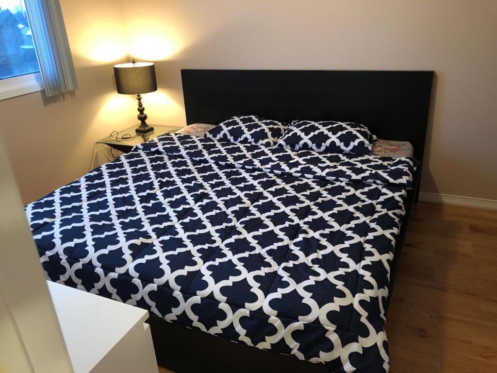 - une chambre avec un lit et une couette bleue et blanche dans l'établissement 4 bed Cozy Basement Apartment with Massage, Gym, Billiards Facilities, à Whitby