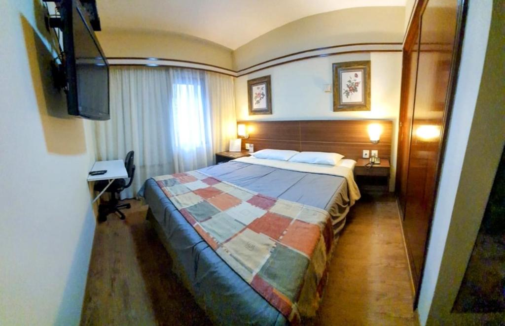 a hotel room with a bed and a flat screen tv at The Time Flat - Berrini - 200 metros do WTC in São Paulo