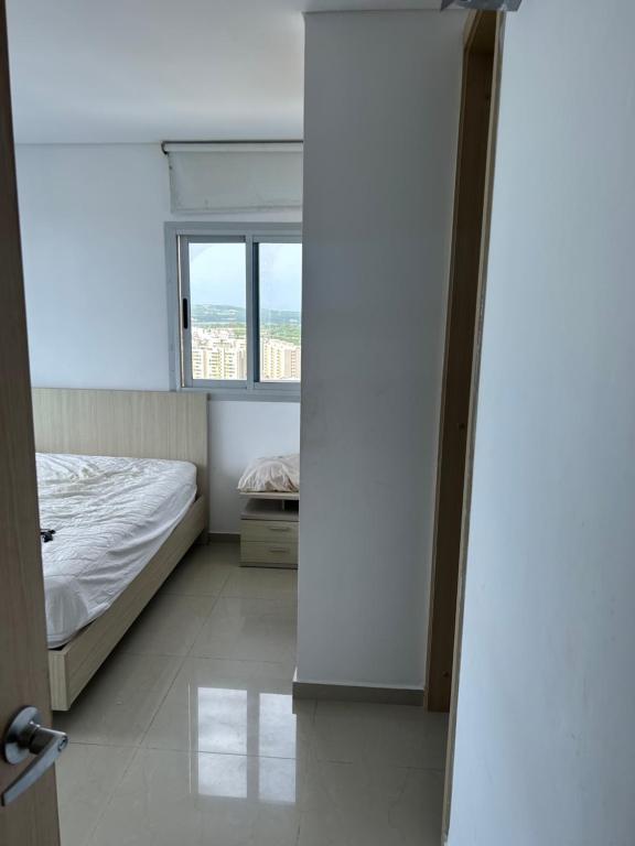 um quarto com uma cama e uma janela em Arriendo Apartamento Amoblado En Puerto Colombia Villa Campestre em Barranquilla