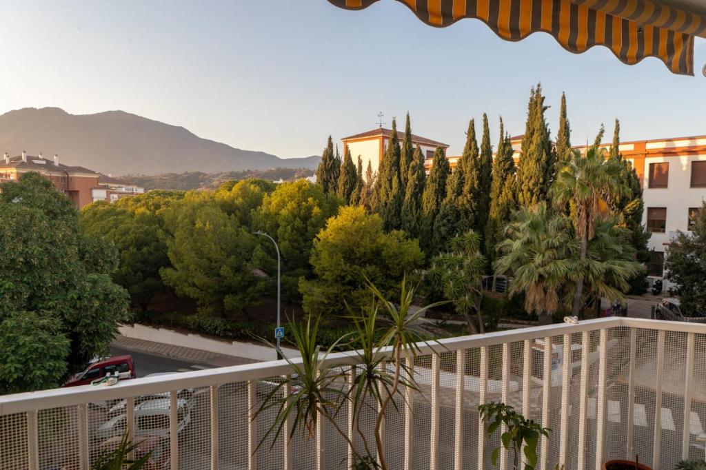 un balcon avec vue sur les arbres et les bâtiments dans l'établissement Apartamento Mariona Home, à Estepona