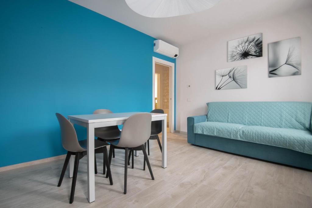 uma sala de estar com uma mesa e cadeiras e um sofá em Alloggio moderno in centro paese em Corneliano d'Alba