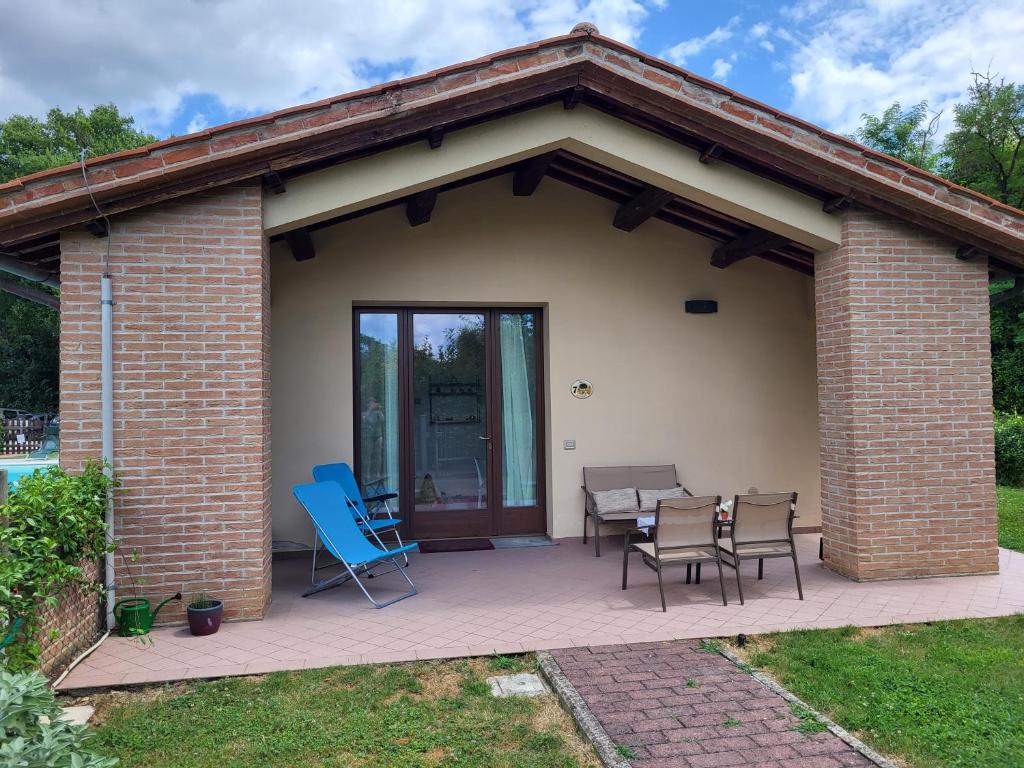 a brick patio with blue chairs and a table at Romantica casa vacanza direttamente in piscina in Castiglione del Lago