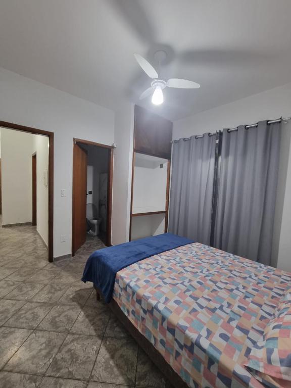 a bedroom with a bed and a ceiling fan at Casa Relaxemar in Caraguatatuba