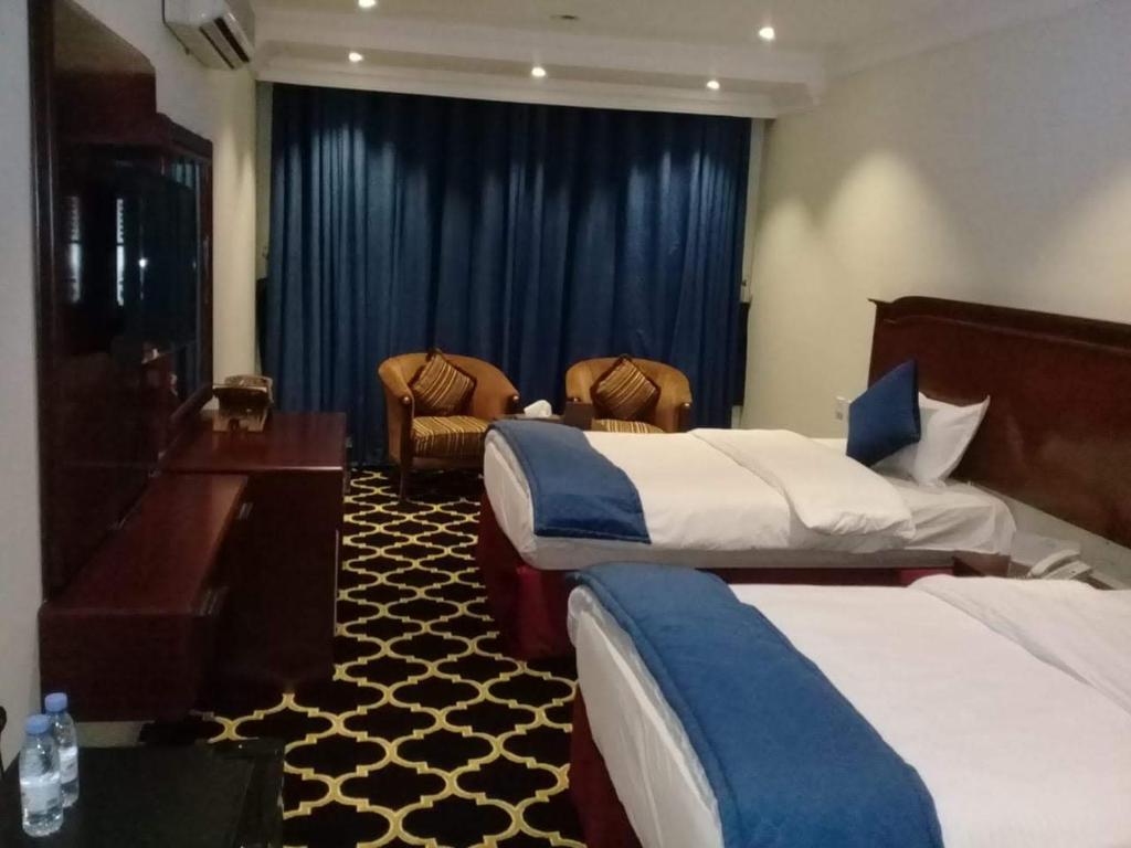 a hotel room with two beds and a piano at قمة البستان in Arar