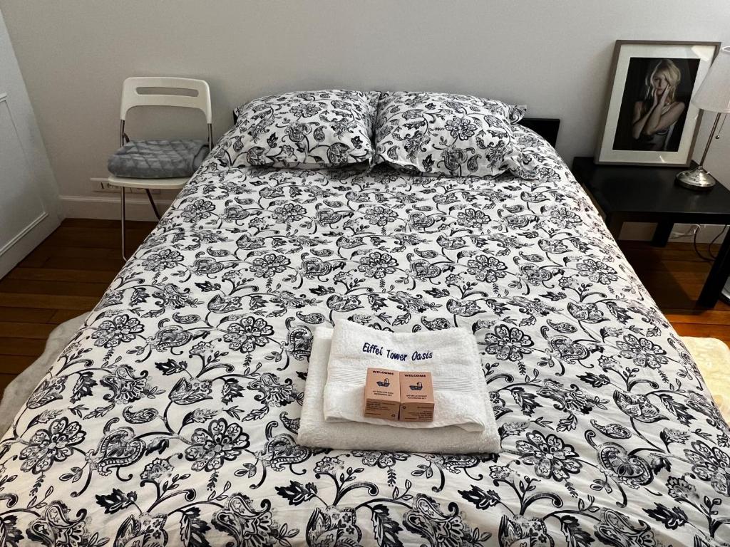 a bed with a black and white comforter and a pillow at Eiffel Tower Oasis 30m from Eiffel Tower in Paris