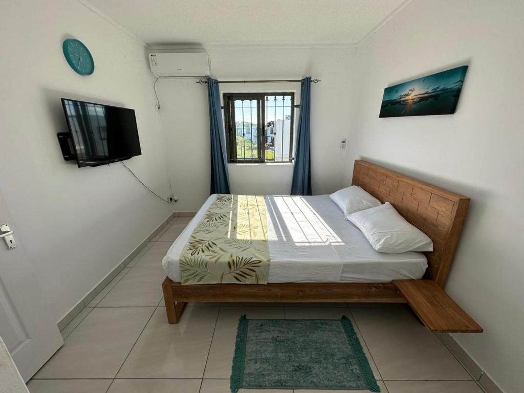 een slaapkamer met een bed en een televisie in een kamer bij Celestial 17 Villa in Grand Gaube