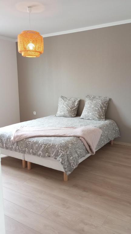a bed in a white room with a lamp at Maison au calme in Livry-Gargan