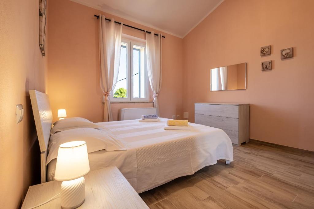 una camera da letto con un grande letto bianco e una finestra di La casa di campagna a Manciano