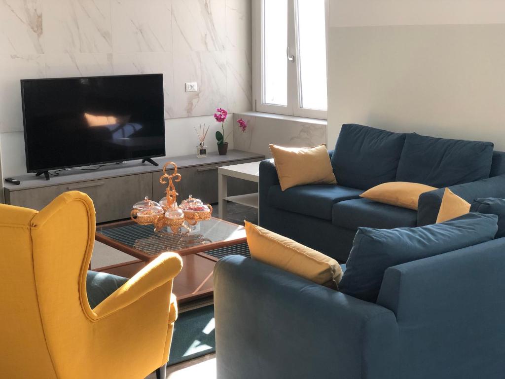 sala de estar con sofás azules y TV en Welcome Milano Guest House, en Milán