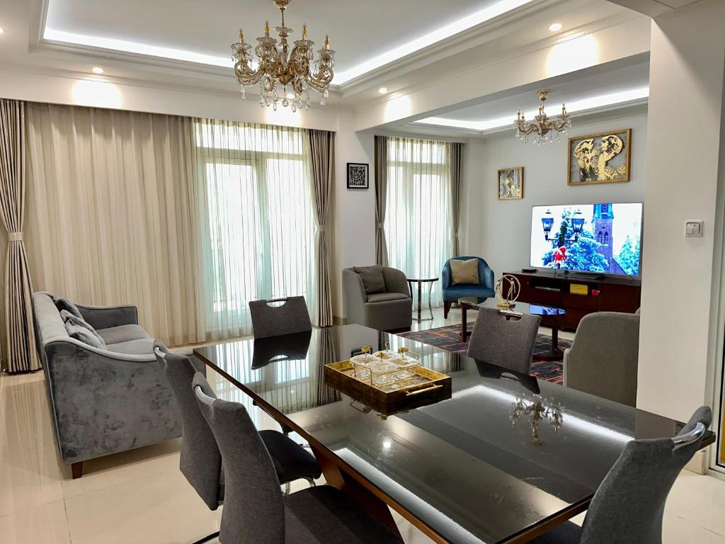 a dining room and living room with a table and chairs at SYN - Mpila in Brazzaville