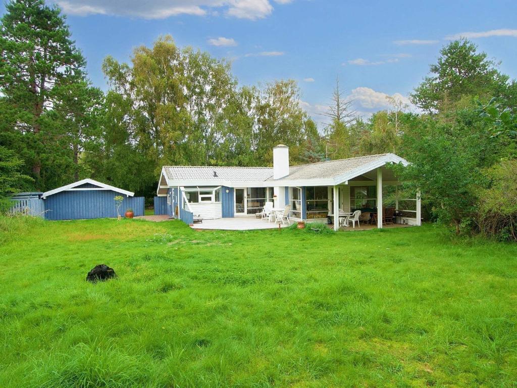a house on a field with a green yard at Luxury Oasis in Pot Strandby-By Traum in Tjørneholm