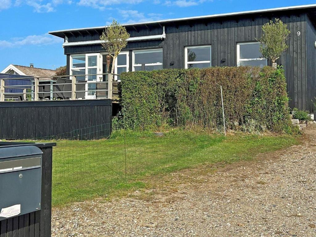 ein Haus mit einem Zaun davor in der Unterkunft 6 person holiday home in Slagelse in Slagelse