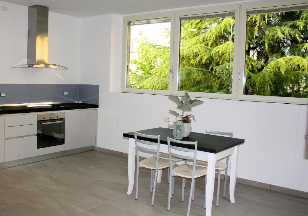 a kitchen with a table and chairs and two windows at Gilda e Vesuvio in Bergamo