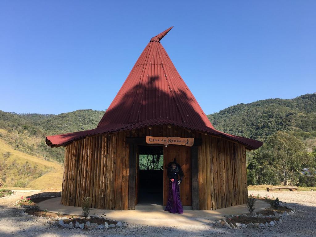 um pequeno edifício de madeira com um telhado vermelho em Hotel Fazenda Morada dos Deuses em Paraibuna